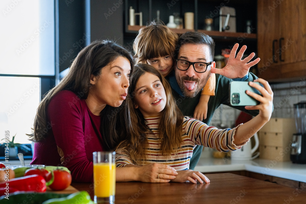 Obraz premium Happy parents with two kids using smartphone at home together, taking selfie, having fun together