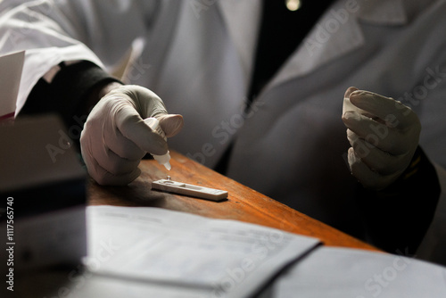 Close-up of a healthcare professional performing a rapid diagnostic test, wearing gloves and a white lab coat. The image captures the precision and care involved in medical diagnostics, with test mate