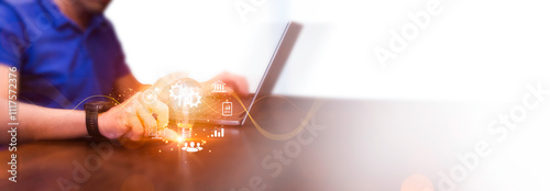Businessman using laptop and holding a bright light bulb with empty space for text. Concept of Ideas for presenting new ideas Great inspiration and innovation new beginning.