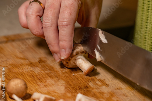 action de découpe d'un champignon de Paris avec un couteau chef, en gros plan