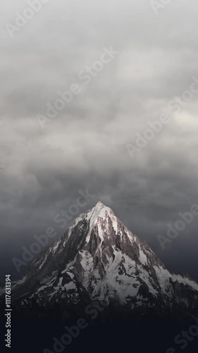 Snowy mountain with cloudy overcast sky vertical looping animation abstract background