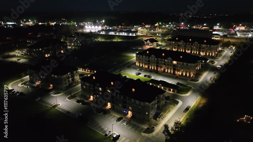 Lighting apartment houses in suburb of american town at night. Aerial top down shot. Parking cars in new developed upscale housing area. Cityscape with highway in background. Timberlake, Virginia,USA photo