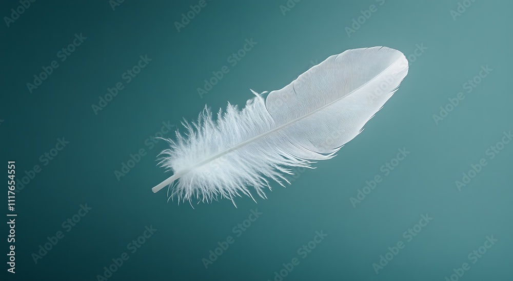A single floating white feather floats in the air against a light blue background, highlighting the softness of the feather. Representing a feeling of calm and tranquility. It looks very beautiful. A single floating white feather floats in the air against a light blue background, highlighting the softness of the feather. Representing a feeling of calm and tranquility. It looks very beautiful.