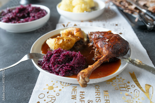 Roasted goose leg with red cabbage, dumpling and brown sauce on a plate photo