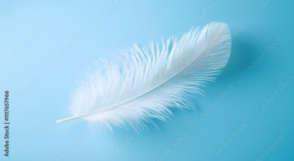 Obraz premium A single floating white feather floats in the air against a light blue background, highlighting the softness of the feather. Representing a feeling of calm and tranquility. It looks very beautiful.