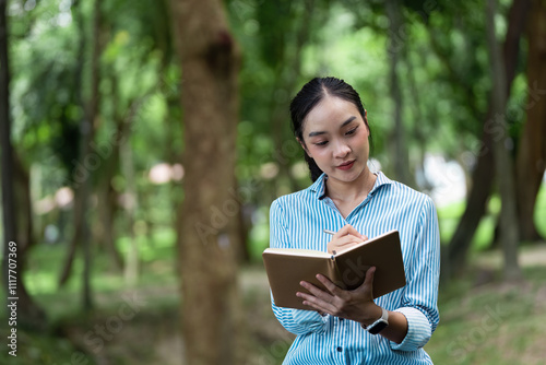 Focused Woman Reading and Working Outdoors in a Serene Park Setting with Nature in the Background photo