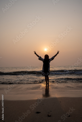 strong confidence woman open arms under the sunrise or sunset at seaside