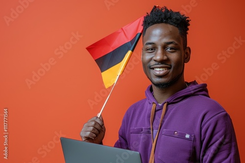 A person sitting with a laptop and a German flag, possibly for patriotic or nationalistic purposes