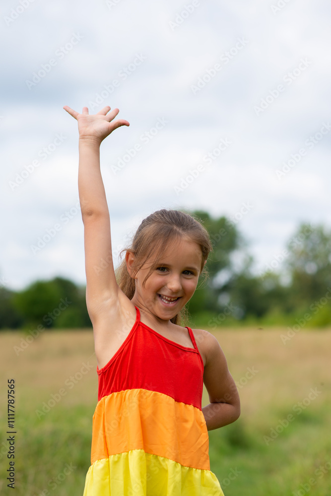 Obraz premium Little happy girl waving her hand