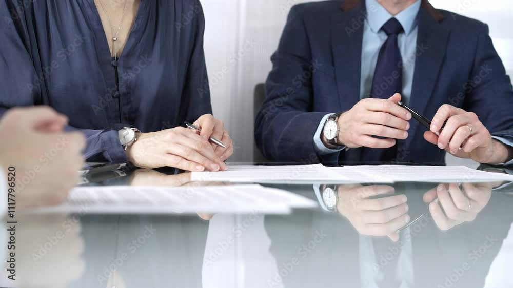 Business partners or lawyers are discussing contract papers during a meeting, negotiating and making decisions together. Business people concept, close up Business partners or lawyers are discussing contract papers during a meeting, negotiating and making decisions together. Business people concept, close up