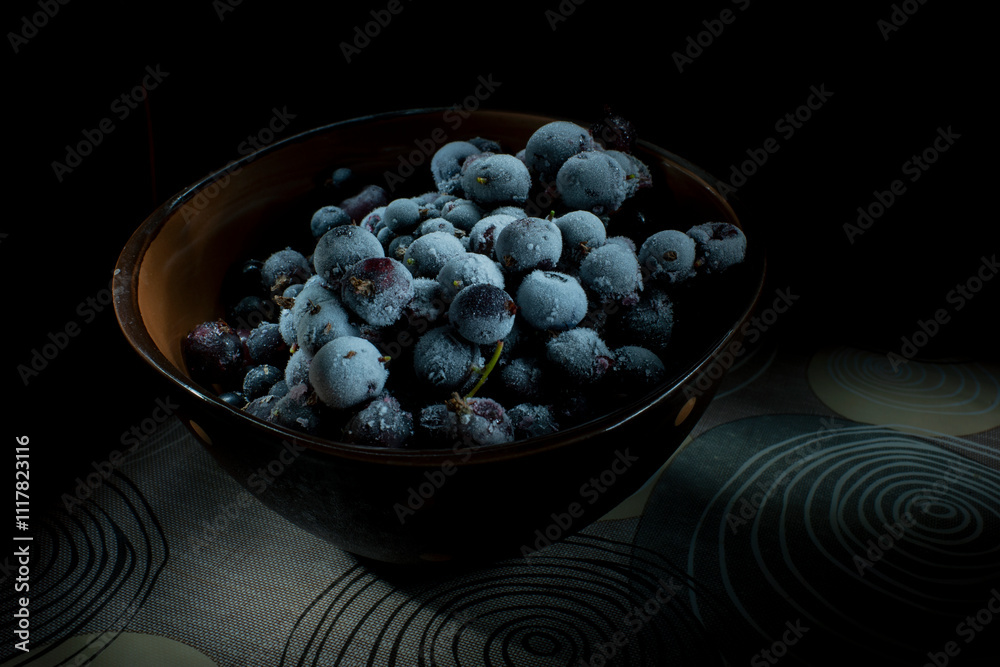 Bowl with frozen berries on a black background, banner addition. Bowl with frozen berries on a black background, banner addition.