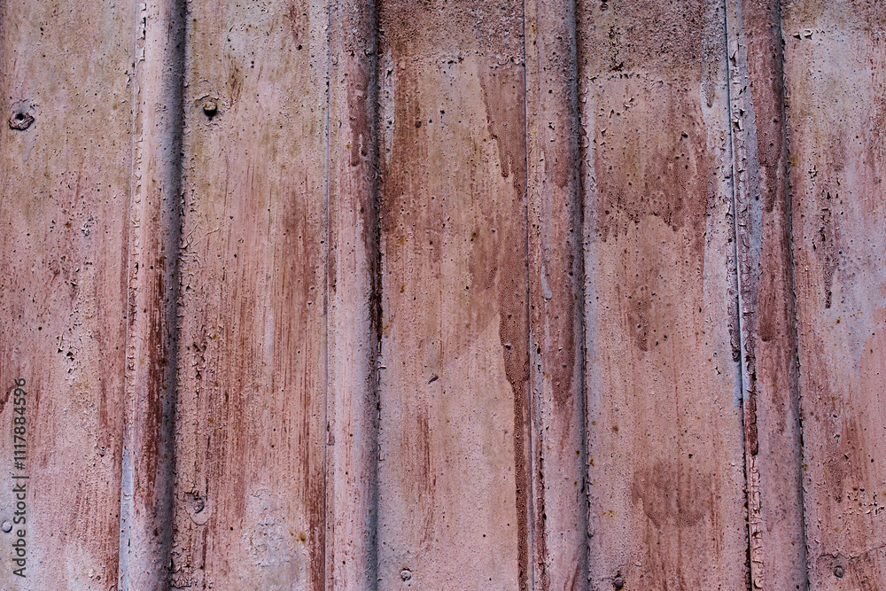 The wall has an uneven color, mostly pinkish-brown, with visible signs of wear and streaks. The surface appears rough and has small holes and cracks. The wall has an uneven color, mostly pinkish-brown, with visible signs of wear and streaks. The surface appears rough and has small holes and cracks.