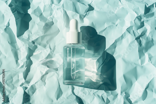 Mock up of transparent glass bottle of cosmetic serum, essential oil, perfume with wooden pipette on top, on crumpled blue paper background, aesthetic style. concept for skin care product presentation