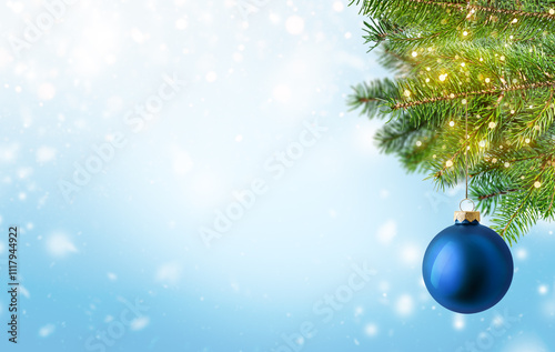 Blue Christmas baubles hanging from fir tree branch with snowy background and bokeh lights. Winter holiday festive backdrop with copy space. Design for banner, greeting card, invitation