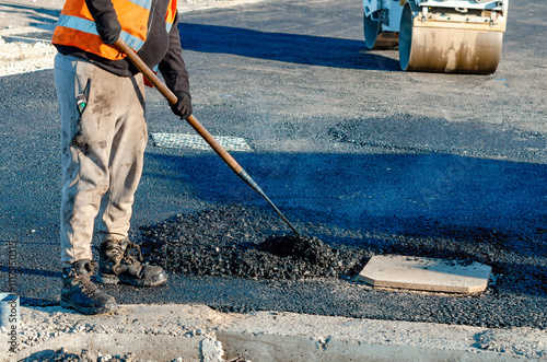 Photos Road repair worker fills pothole with fresh asphalt during daytime construction