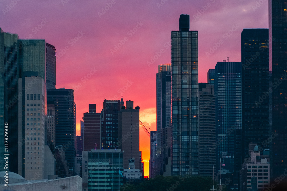 Naklejka premium Spectacular Cityscape at Sunset with Illuminated Modern Skyscrapers Against a Vibrant Pink and Orange Sky Capturing the Beauty and Energy of Urban Life as Day Transitions into Night