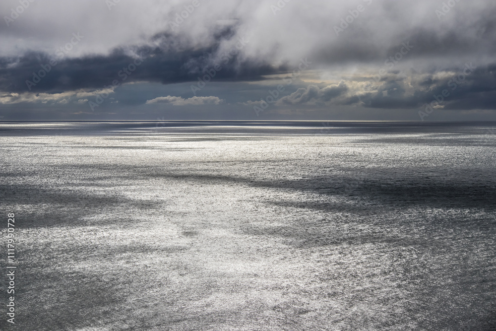 Dark stormy clouds over calm flat ocean Dark stormy clouds over calm flat ocean
