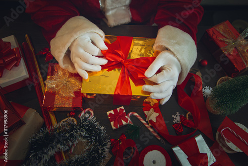 Santa Claus hands wrapping Christmas gift boxes. photo