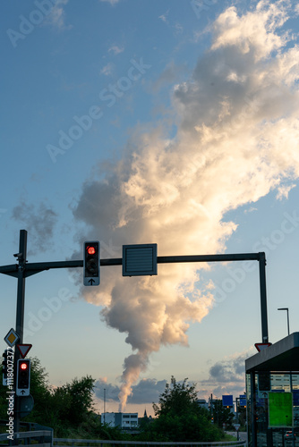 Huge steam cloud of a nuclear power plant, that is located way in the distance, and not visible on this photograph. Traffic lights and street in the foreground. photo