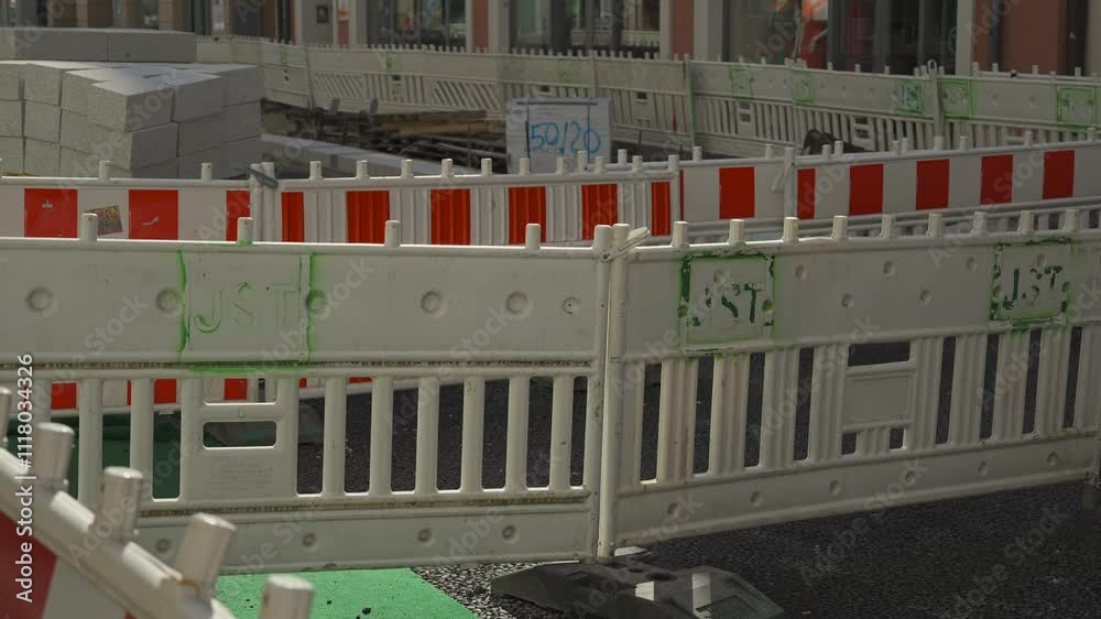 Barrier fencing of a construction site with red and white markings in Freising, Bavaria, Germany. Fencing during renovation of light signal is enclosed with standard protective plastic shields Barrier fencing of a construction site with red and white markings in Freising, Bavaria, Germany. Fencing during renovation of light signal is enclosed with standard protective plastic shields