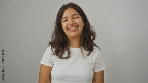 Attractive young hispanic brunette woman smiling brightly over a white background wall in an isolated setting.