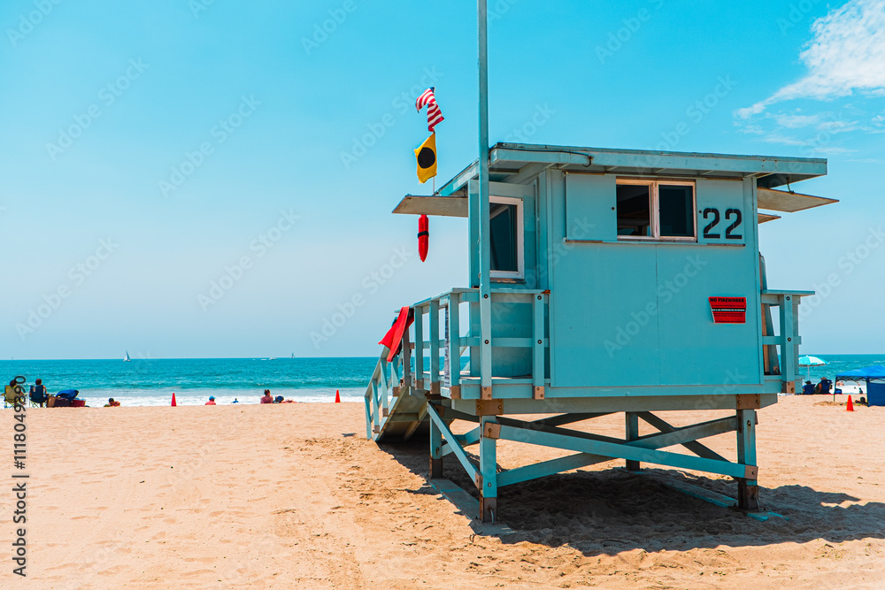 Obraz premium Vibrant Beach Scene with Iconic Lifeguard Tower and Relaxed Atmosphere Under Blue Sky