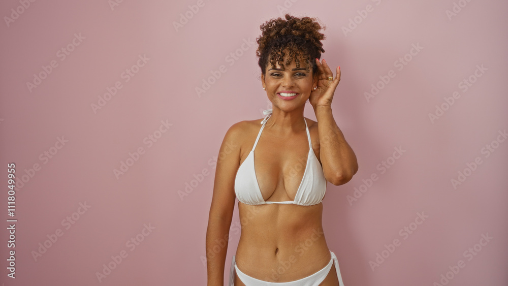 Naklejka premium Beautiful young hispanic woman in white bikini over isolated pink background