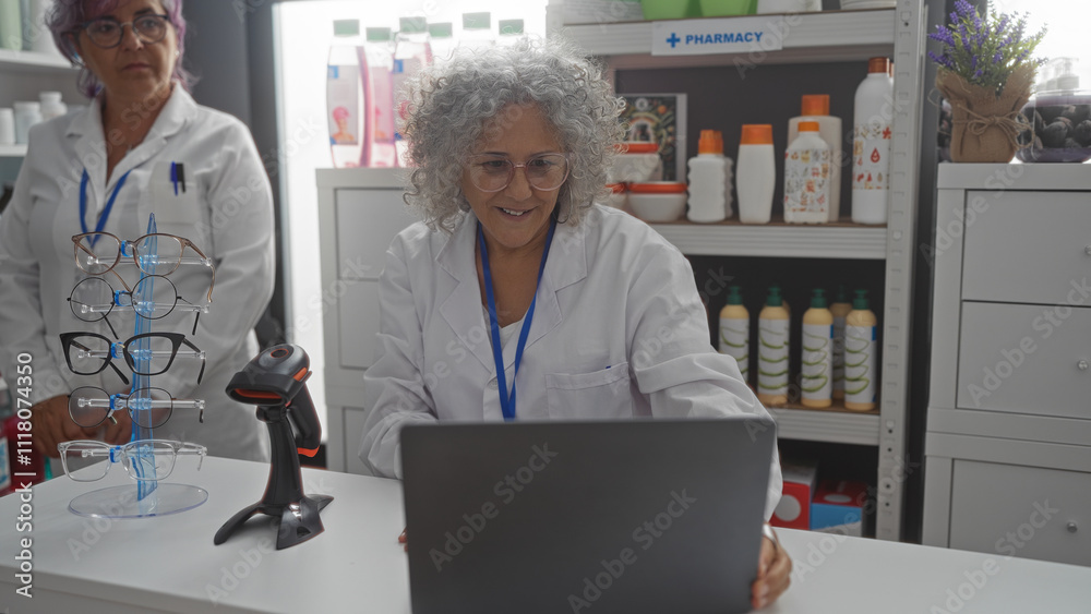 Elderly women pharmacists working together in a pharmacy store interior with eyeglasses and medical supplies Elderly women pharmacists working together in a pharmacy store interior with eyeglasses and medical supplies