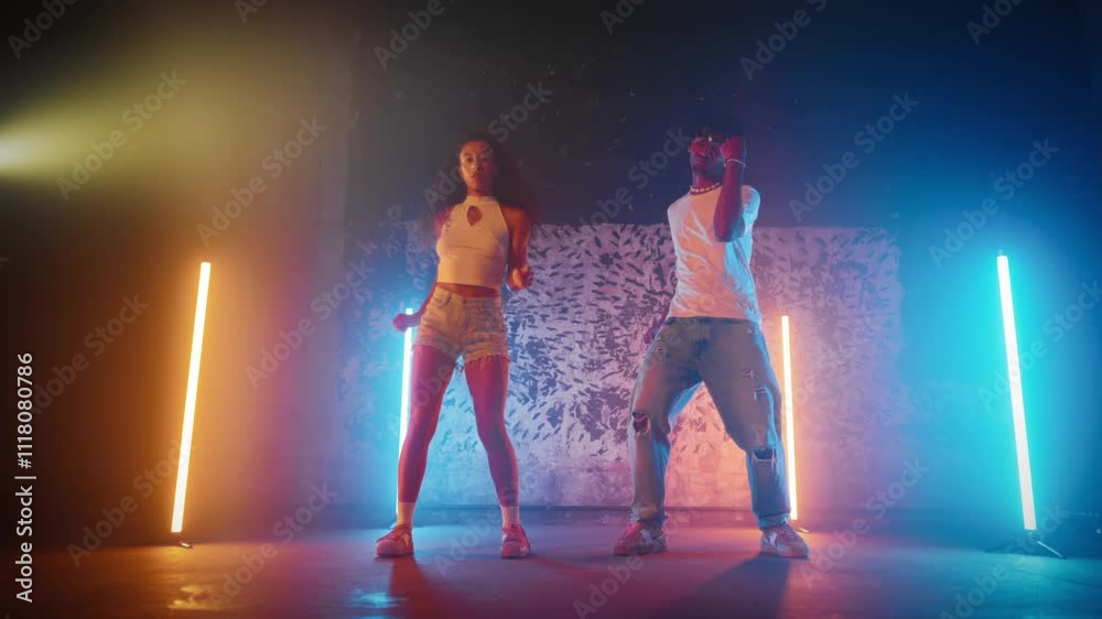 Dance party, African American man and woman dancing modern and ethnic dance. Energy of music, young adult dancers moving in dance studio, full-length portrait, enjoy rhythm and sounds of favorite song