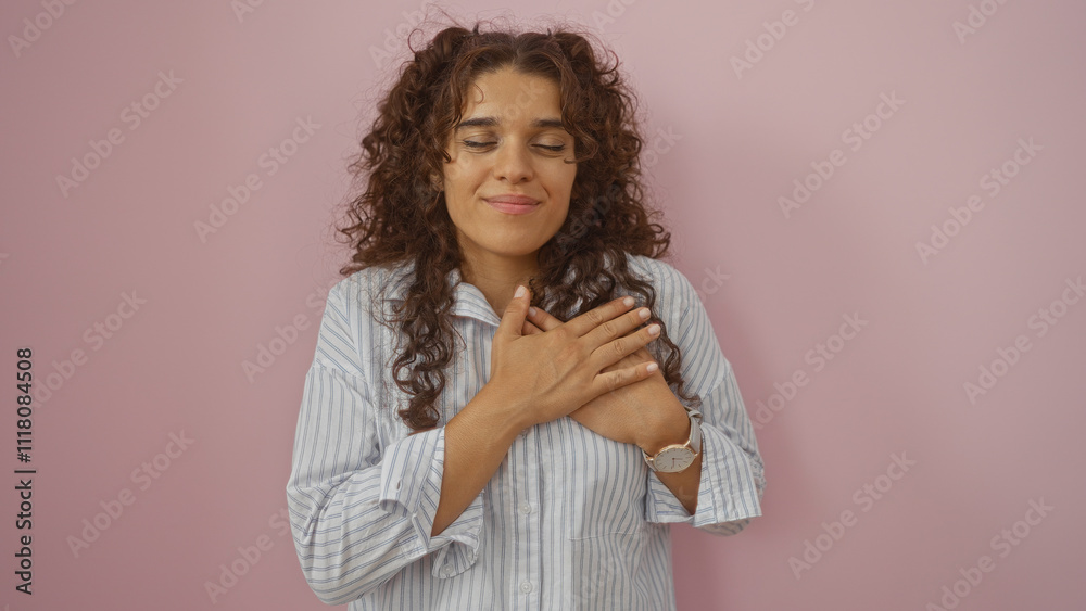 Young woman with hands on heart over isolated pink background, displaying gratitude and happiness Young woman with hands on heart over isolated pink background, displaying gratitude and happiness