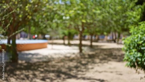 Blurry image of an outdoor park with trees and shaded ground, creating a serene and calm environment.