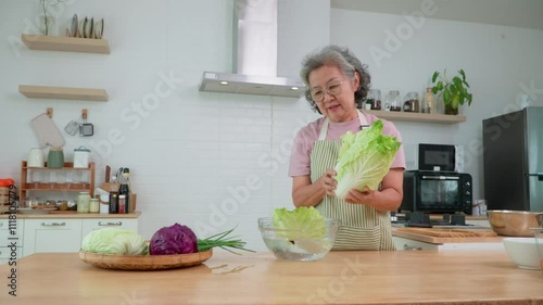 Happy Asian senior woman with a warm smile, prepares a healthy meal in her kitchen. he prepares fresh vegetables in her kitchen, creating heartwarming scene of culinary delights, Health care concept