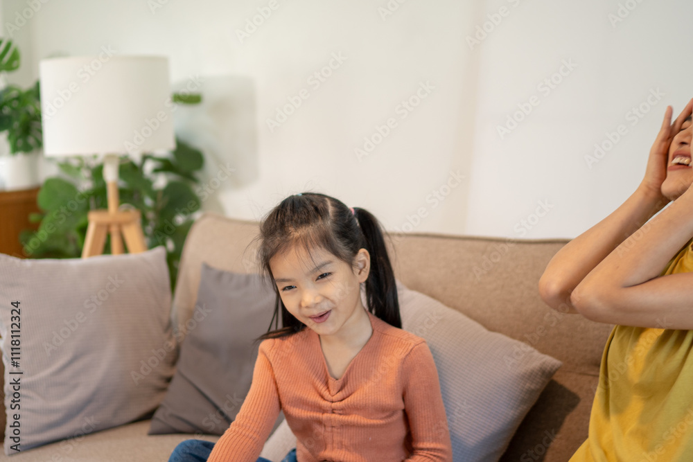 Lovely mom and little young daughter spending time together in their living room. Lovely mom and little young daughter spending time together in their living room.
