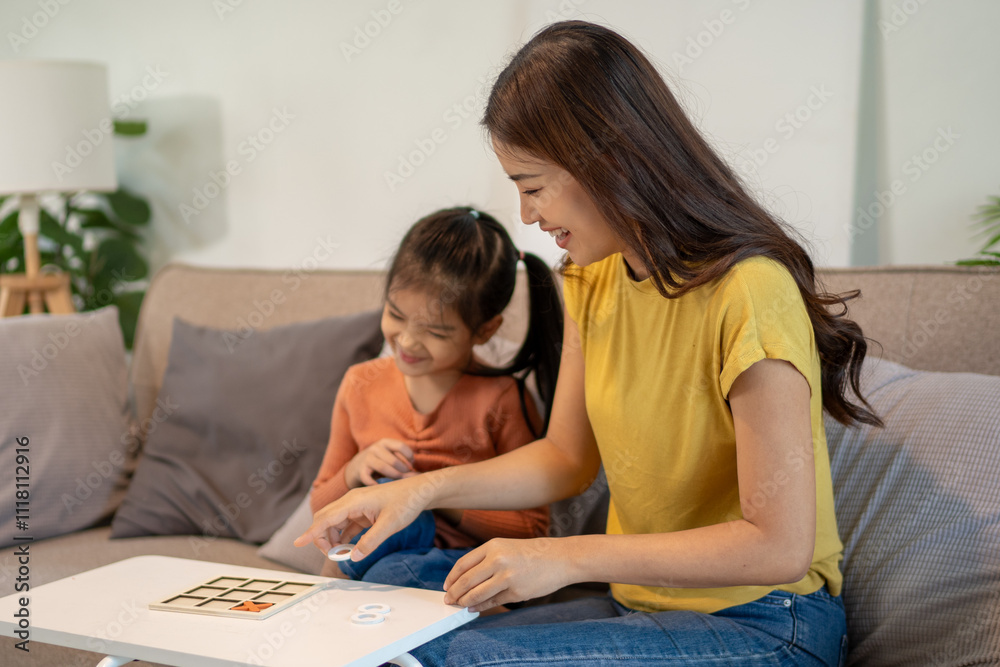 Lovely mom and little young daughter spending time together in their living room. Lovely mom and little young daughter spending time together in their living room.