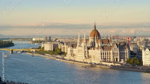 Stunning view of the Hungarian Parliament before sunset, with beautiful yellow tones and wispy clouds enhancing the charm of Budapest, capturing the city's essence as day transitions into evening
