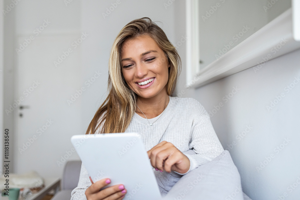 Smiling Woman Relaxing at Home While Using a Tablet Device Smiling Woman Relaxing at Home While Using a Tablet Device