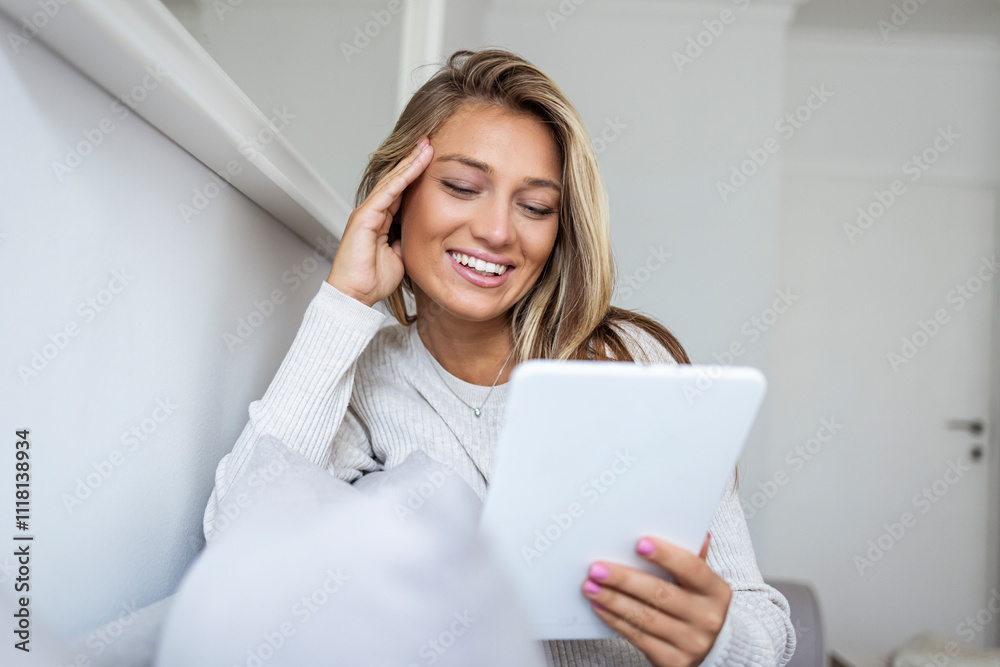 Smiling Woman Relaxing at Home Using Digital Tablet for Entertainment Smiling Woman Relaxing at Home Using Digital Tablet for Entertainment