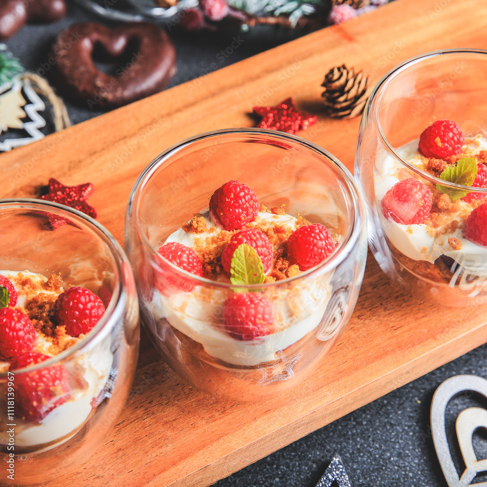 Verrine of crushed speculoos, mascarpone and raspberries on a gray background decorated for Christmas