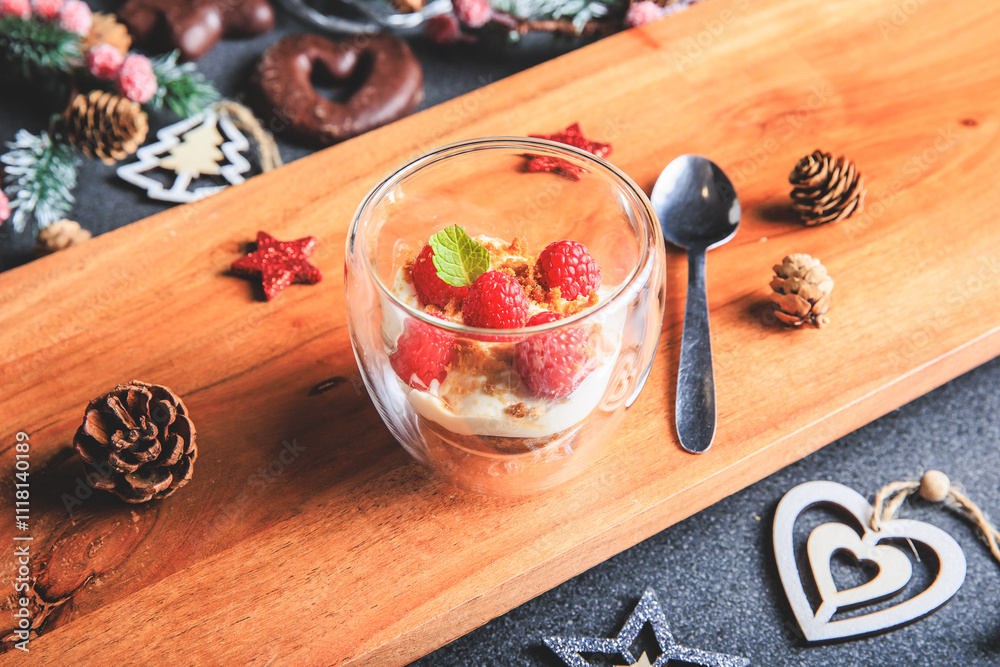 Verrine of crushed speculoos, mascarpone and raspberries on a gray background decorated for Christmas