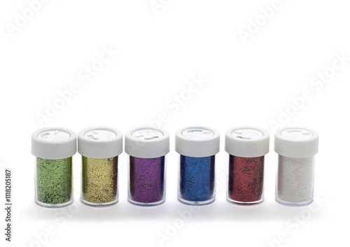 A row of colourful craft glitter in small jars on a white back ground.