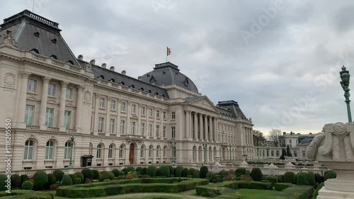 Belgian flag is waiving on top of the Royal Palace of Brussels. It is the official palace of the Belgian Royal family in the city centre. Front facade. Bruxelles, Brussels capital region, Belgium photo