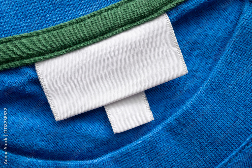 Blank white laundry care clothes label on blue shirt fabric texture background Blank white laundry care clothes label on blue shirt fabric texture background