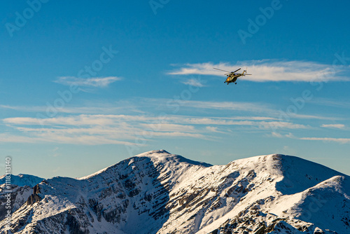 Obraz na płótnie Góry Tatry zimą i widoczny latający helikopter w salonie