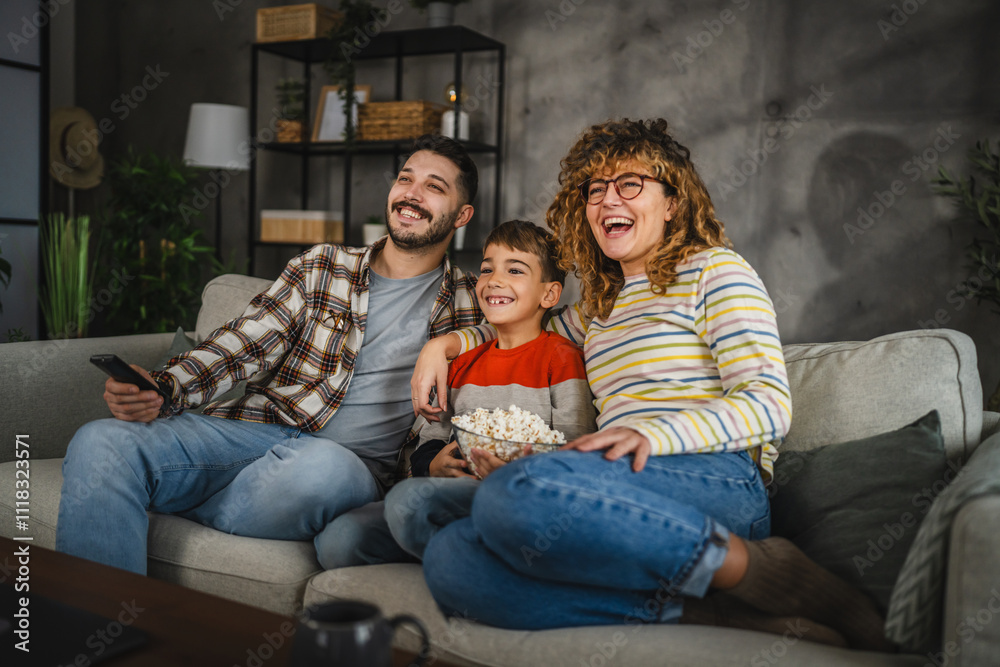 Mum, dad and son watch cartoon or movie on television and sit on sofa Mum, dad and son watch cartoon or movie on television and sit on sofa