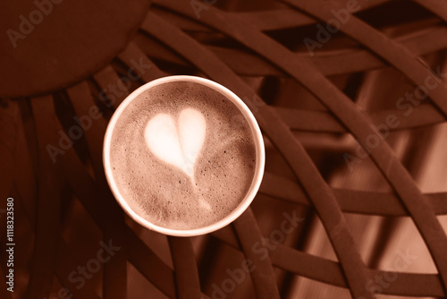 Coffee in paper cup on brown vintage metal table. Top view. Demonstrating color of the year 2025 - Mocha Mousse