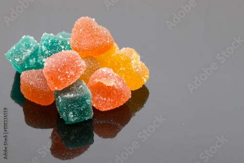 Colorful Sugary Candies Piled on Reflective Black Surface