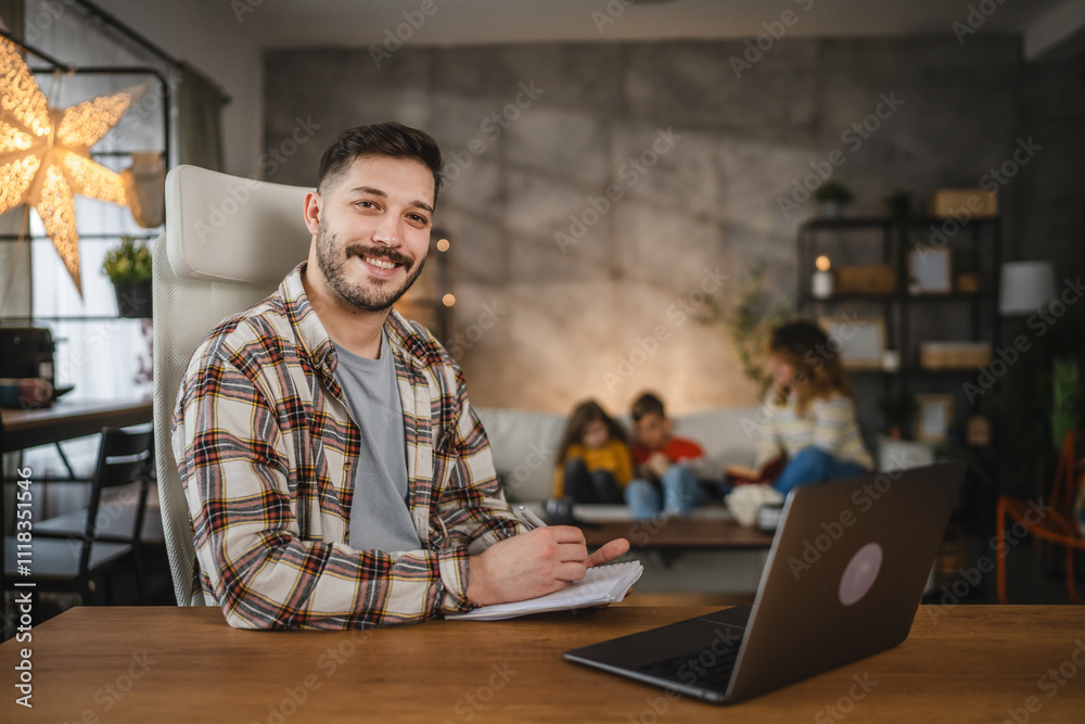 Fototapeta premium dad work from home take a notes in a notebook from laptop