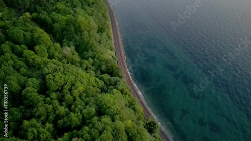 Island coast divided by train track, tropical coastline with beautiful turquoise blue water from aerial view 