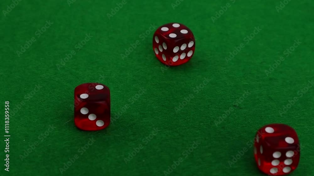 Casino dice falling and spinning on green felt gambling table close-up