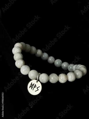 bracelet made of expensive natural stone with silver inserts and a pendant with runes